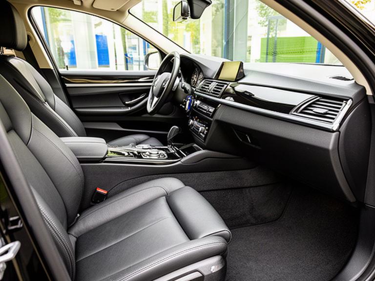 Pristine black car interior in Croydon with clean leather seats, bright carpets and a spotless dashboard